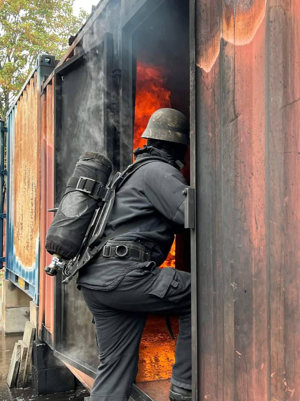 Teilnehmer gehen in befeuerten Container