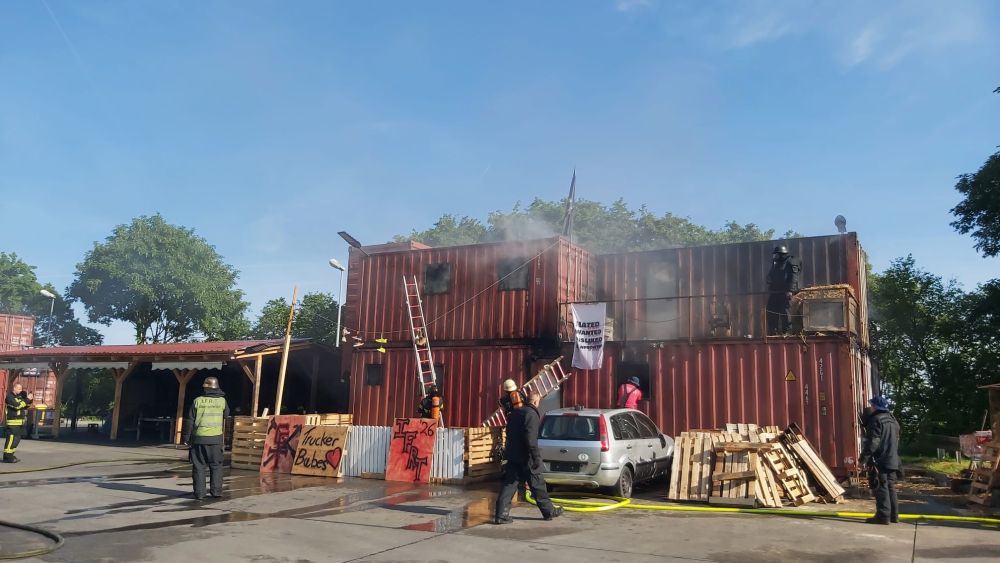 Containeranlage mit Leitern und Rauch